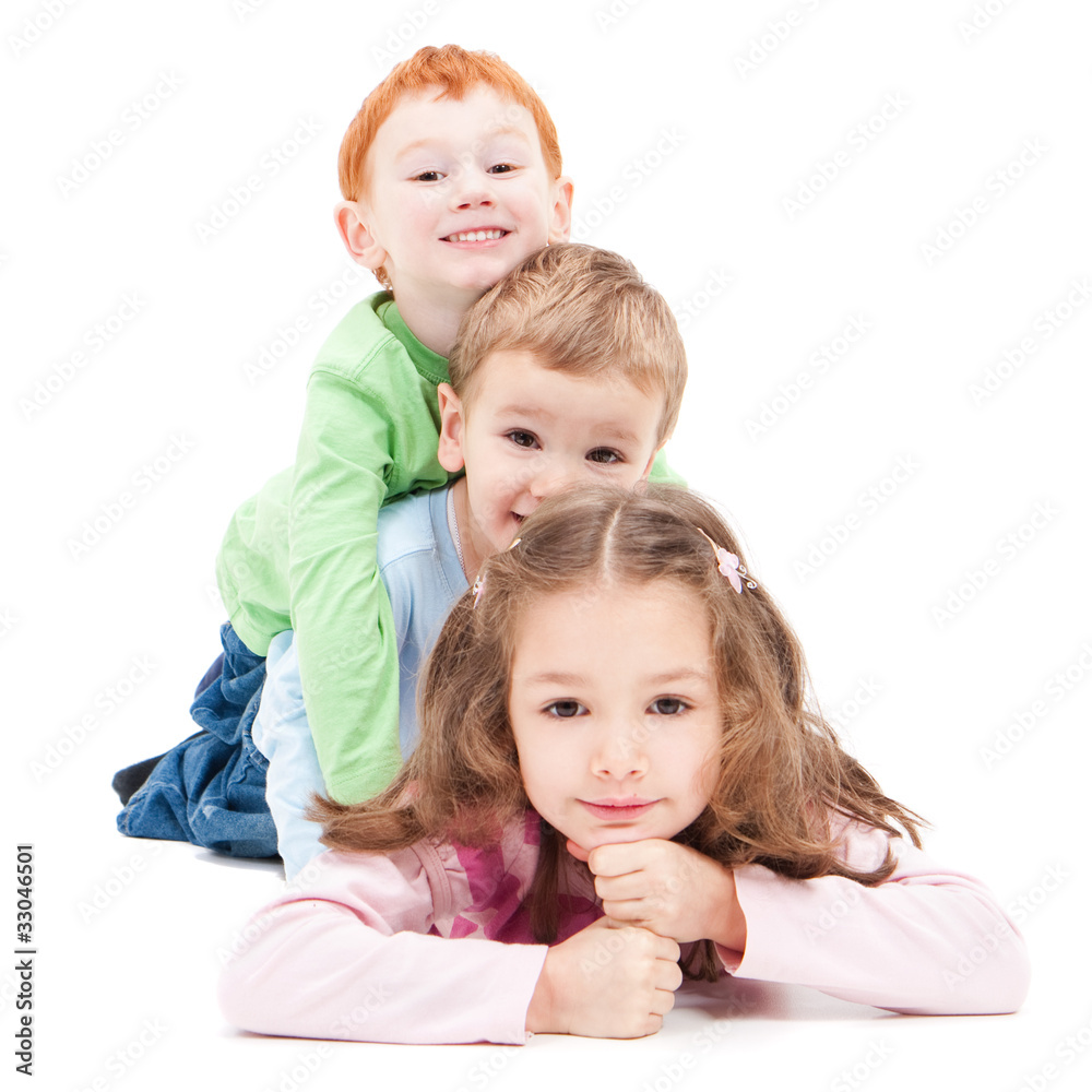 Three smiling kids lying on top of each other Three smiling kids lying on top of each other