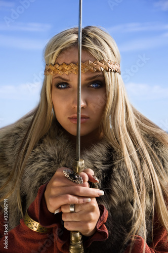 Viking girl warrior on a blue sky background photo