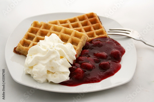Fotografie Waffeln mit heißen Kirschen und Sahne
