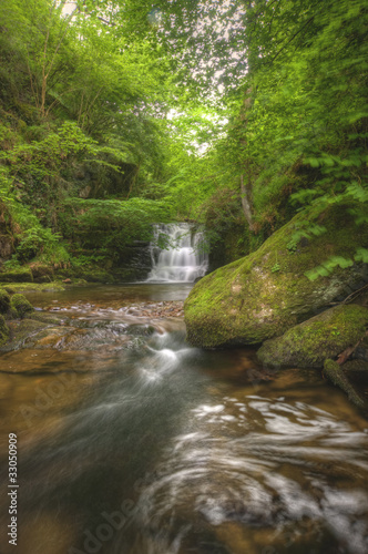 Stunning waterfall flowing over rocks through lush green forest