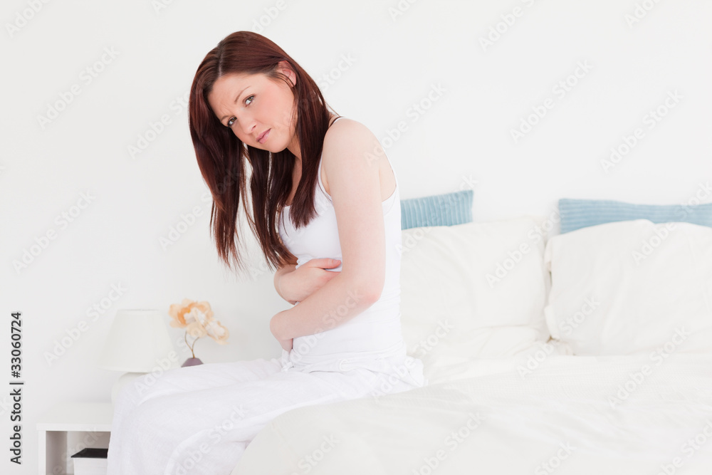 Sick red-haired female posing while sitting on her bed Sick red-haired female posing while sitting on her bed