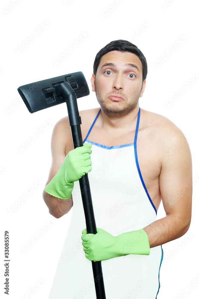 Sad young man in apron holding vacuum cleaner brush Sad young man in apron holding vacuum cleaner brush