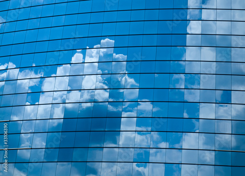 Clouds reflected in windows of modern office building