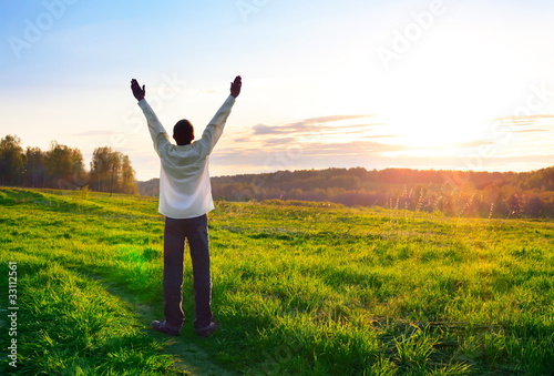 praying man silhouette on sunset background