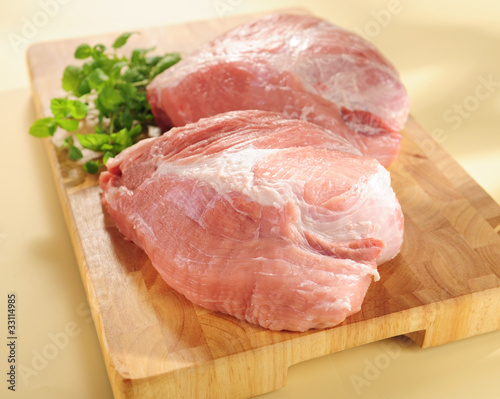 Raw pork shoulder. Arrangement on a cutting board.