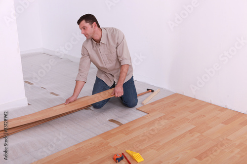 Man renovating the floor with wood panels