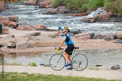 A mature cyclist takes a break by the river