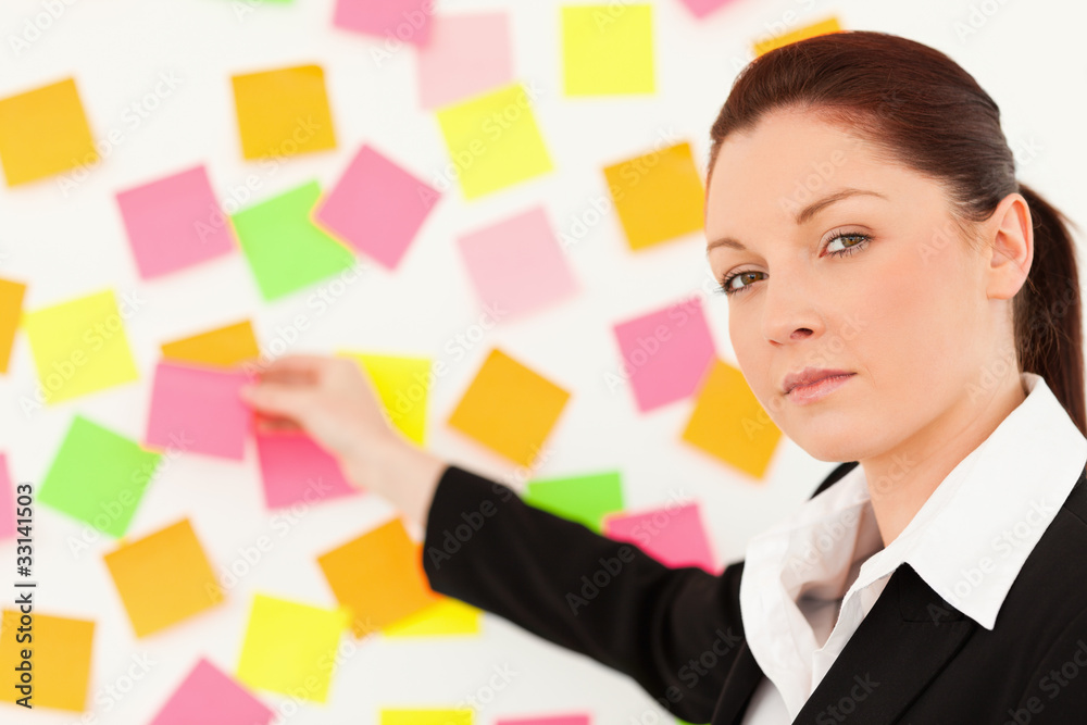 Responsible woman putting repositionable notes Responsible woman putting repositionable notes