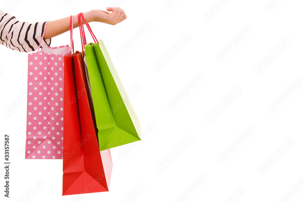 Female hand holding colorful shopping bags, isolated over white
