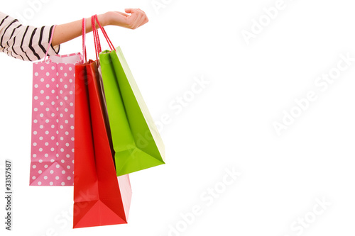 Female hand holding colorful shopping bags, isolated over white