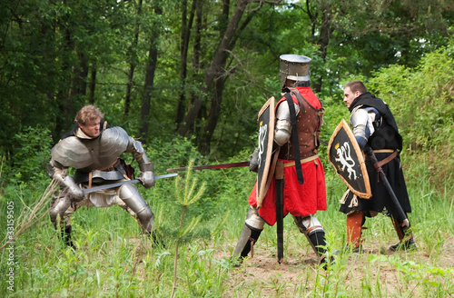 three knights in armor is fighting