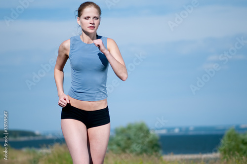 Young sport woman running on sunny day