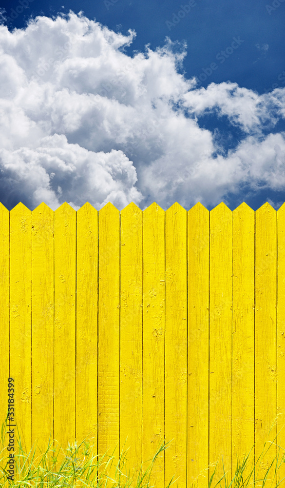 Fototapeta premium yellow picket fence and sky clouds