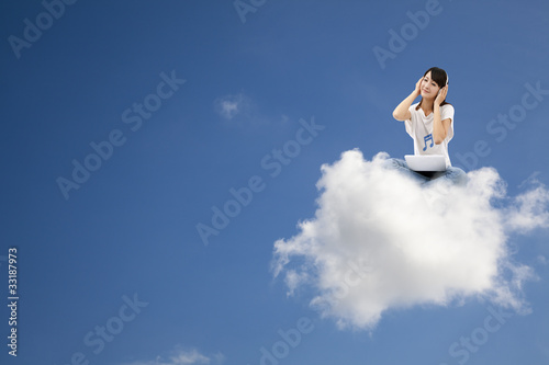 smiling woman listen to music and sitting on the cloud