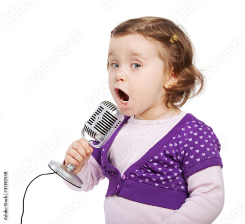 Little girl in violet sings intj the microphone. photo