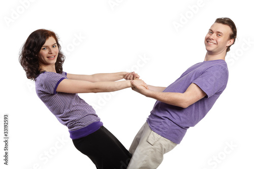 man and woman stand, holding each other's outstretched arms
