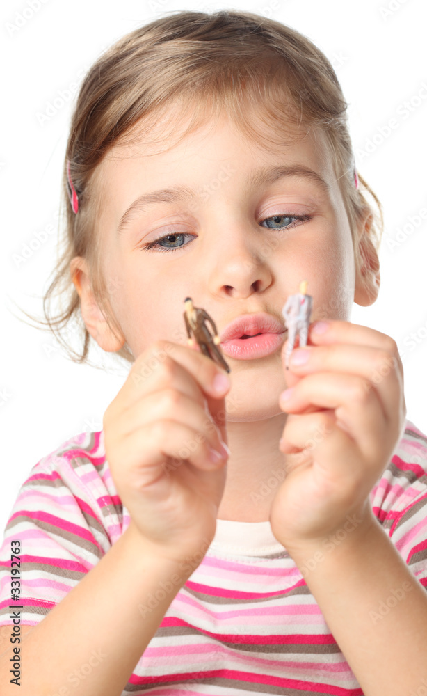 little girl holding small toy figures of people isolated little girl holding small toy figures of people isolated