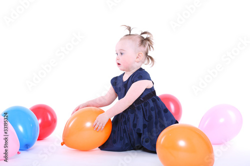 little girl plays with color balloons