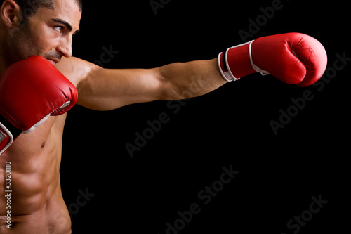 Young Boxer fighter over over black background