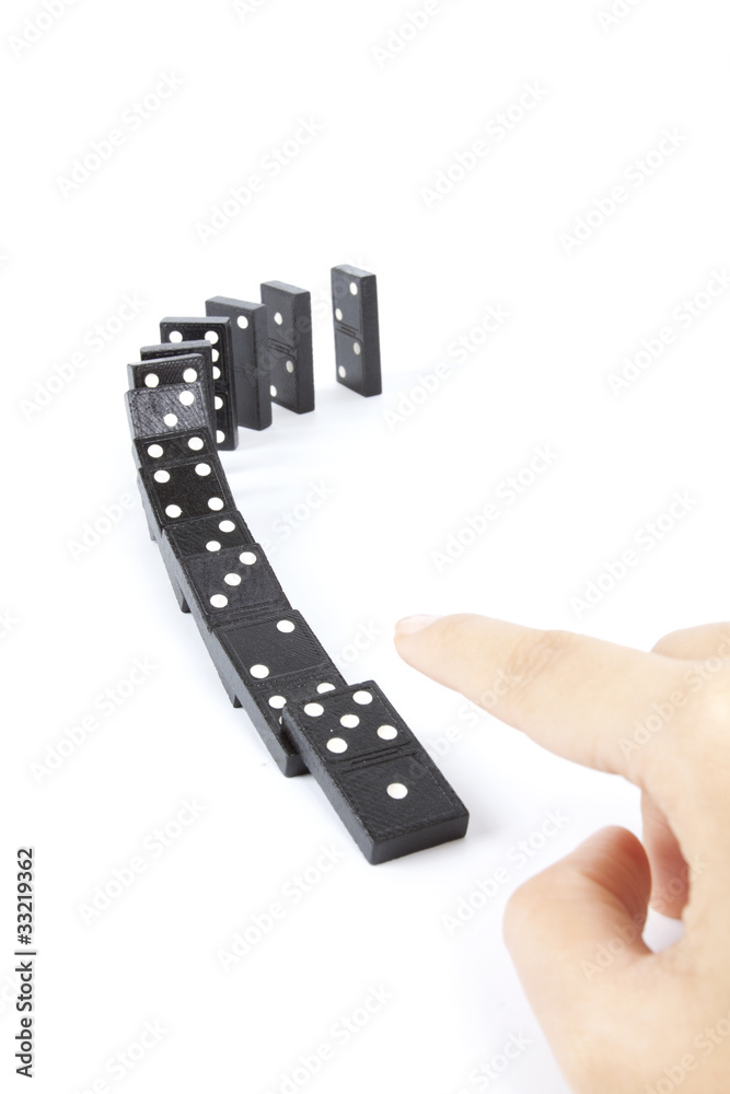 dominos arranging in line and hand fall them down.