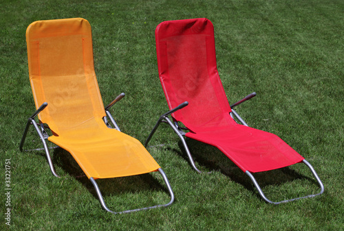 Red and yellow sunbed on grass outdoor