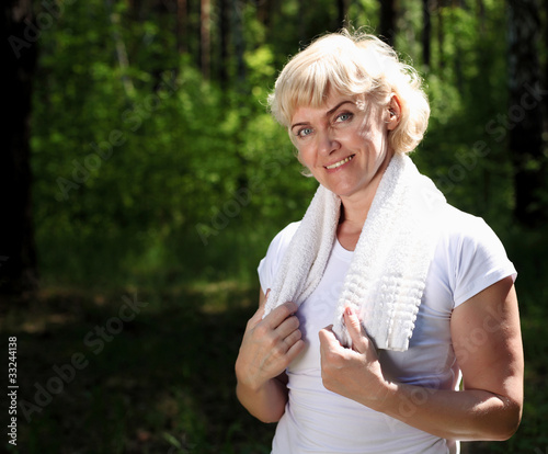 Portrait of an elderly woman in sportswear with a towel