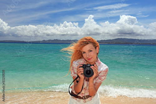 水納島のビーチでカメラを持っている笑顔の女性