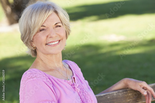 Happy Senior Woman Sitting Outside Smiling photo