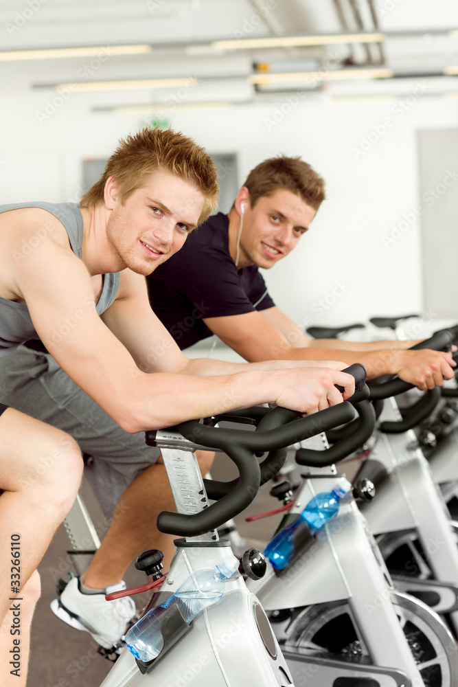 Fitness young man on gym bike spinning