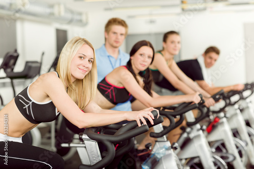 Young fitness people bike spinning with instructor