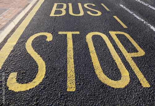 Bus stop sign painted on asphalt road