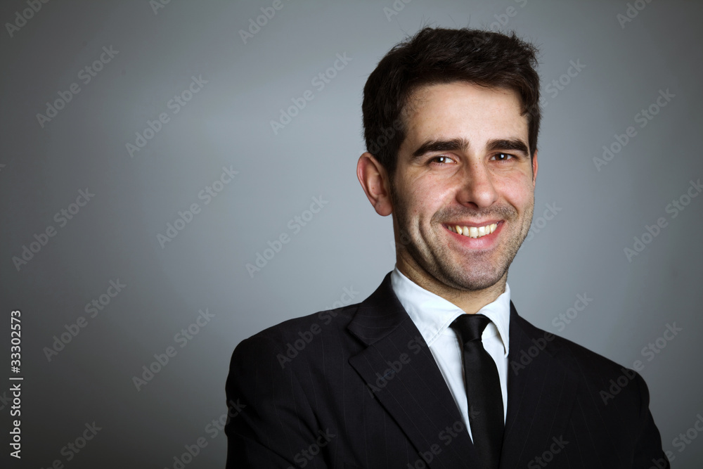 Close-up portrait of a handsome young business man on grey backg Close-up portrait of a handsome young business man on grey backg