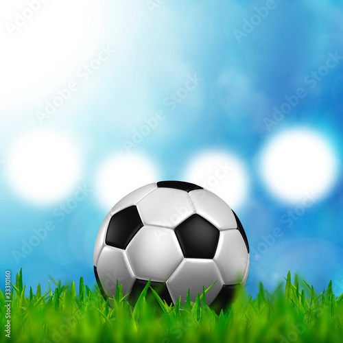football in green grass over a blue sky