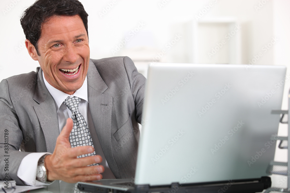 Man laughing hysterically at his laptop computer Man laughing hysterically at his laptop computer
