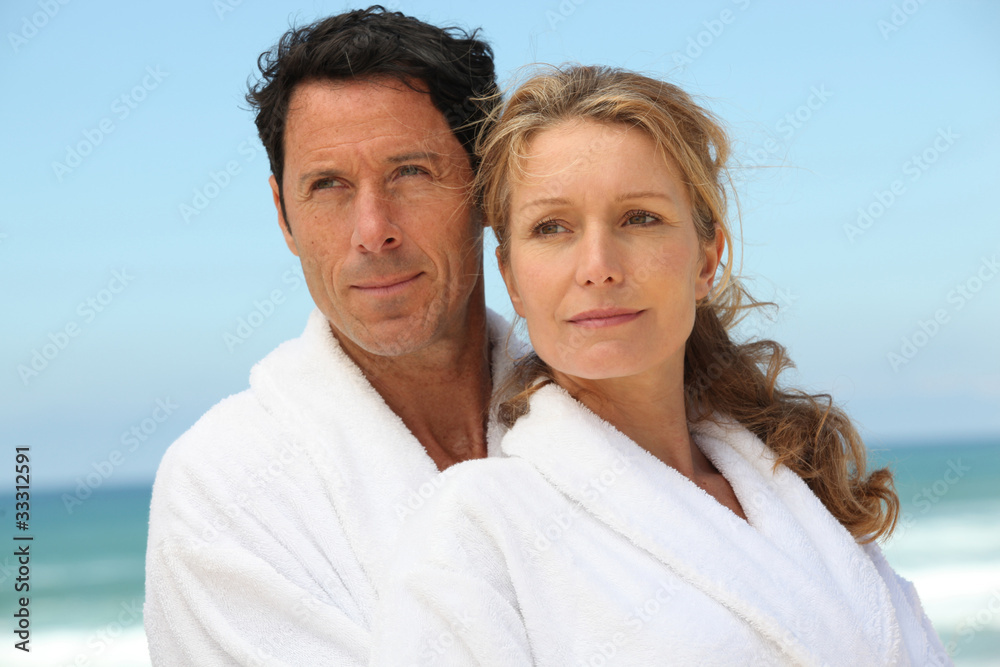 Couple on the beach in white dressing downs Couple on the beach in white dressing downs