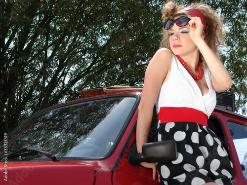 Girl in dress with red comapct car