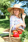 Woman with a straw hat and basket of vegetables.