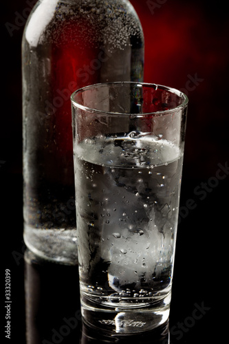 Acqua in bicchiere di vetro con bottiglia