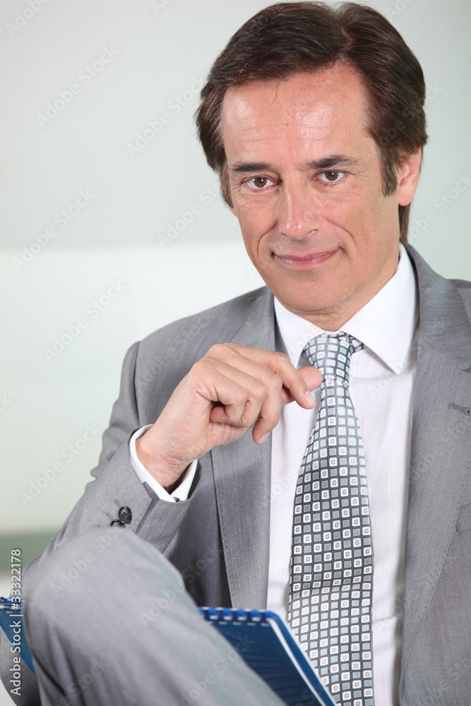 Businessman smiling with notepad. Businessman smiling with notepad.