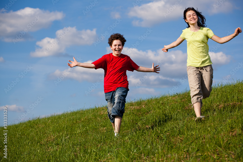 Girl and boy running, jumping against blue sky Girl and boy running, jumping against blue sky