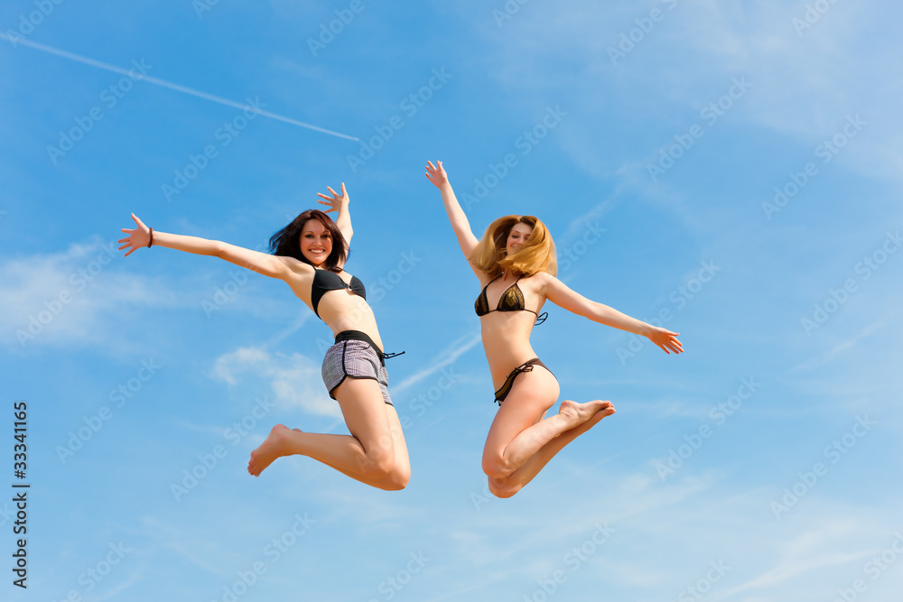 Two happy women jumping high with fun