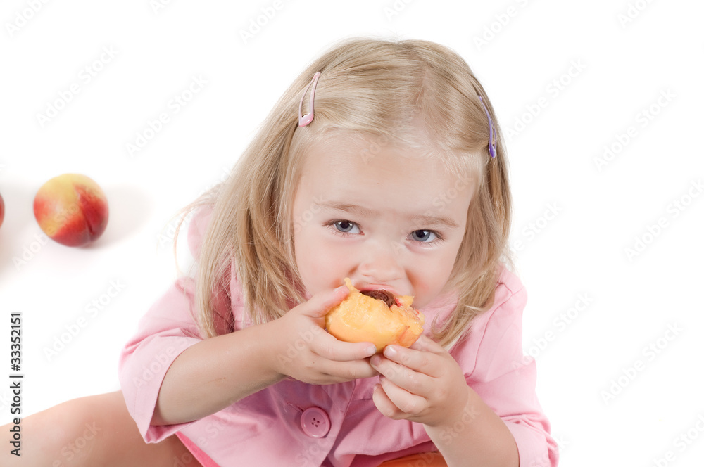 Little girl eating peach in studio Little girl eating peach in studio