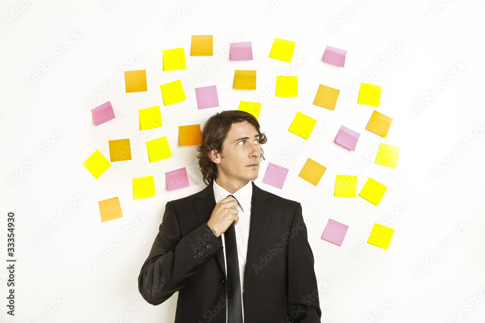 young businessman with postit reminder notes on the background young businessman with postit reminder notes on the background