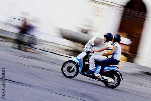 Scooter in movimento con due ragazzi photo