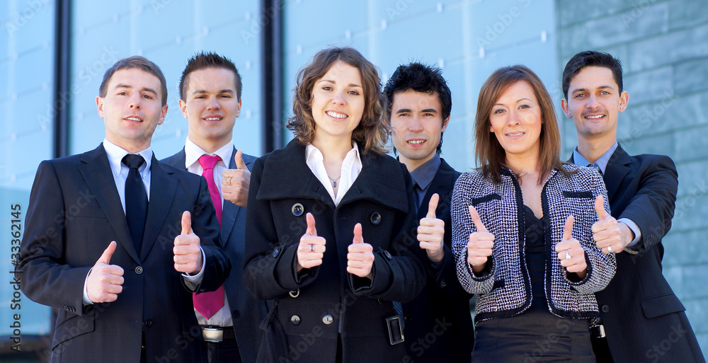 A business team in formal clothes holding thumbs up A business team in formal clothes holding thumbs up
