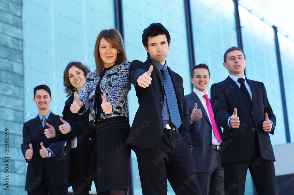 A business team in formal clothes holding thumbs up A business team in formal clothes holding thumbs up
