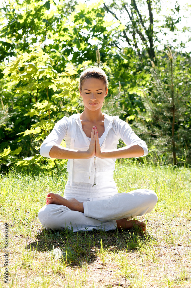 A young and attractive woman is meditating in a forest A young and attractive woman is meditating in a forest