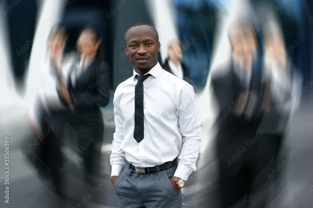 A young and handsome businessman in front of his colleagues A young and handsome businessman in front of his colleagues