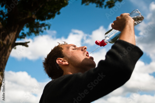 sportsman drinking water after training photo