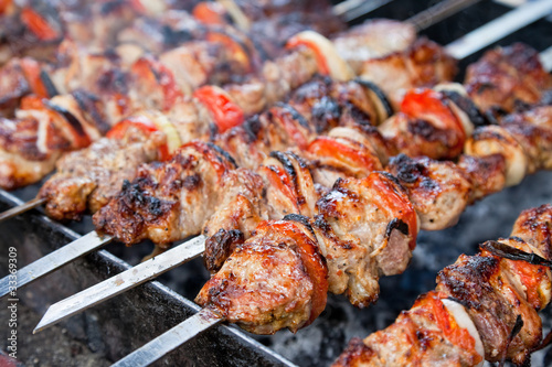 Juicy slices of meat with sauce prepare on fire (shish kebab)